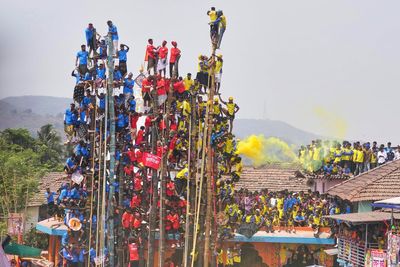 Villagers compete to erect huge bamboo poles at an Indian folk festival, in photos