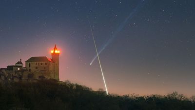 'What are the odds': Superbright comet and exploding fireball meteor form near-perfect X over European castle