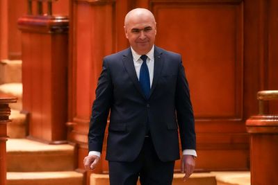 Romania's prime minister fights for survival as no-confidence motion is debated in Parliament