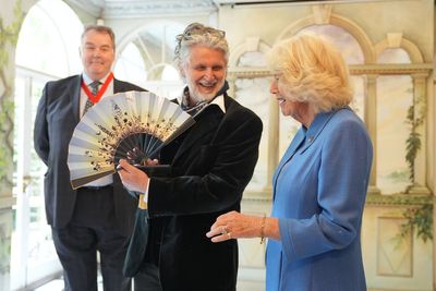 Camilla given fan from coronation portrait on visit to museum’s new exhibition