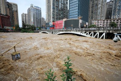 Rescue workers swim through buildings to reach trapped residents as heavy rains kill 24 in China