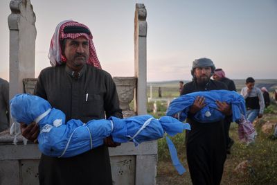 A grieving father buries his 6-year-old after a land mine kills 3 children in Syria's Idlib