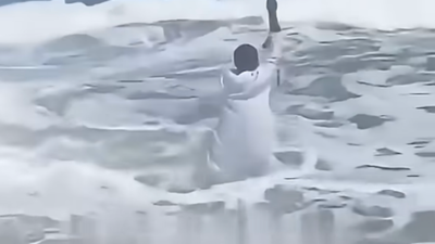 'Fake Moses' Draws a Crowd of Onlookers as He Tries to Part the Sea With Arms Raised Only for the Sea to Push Back