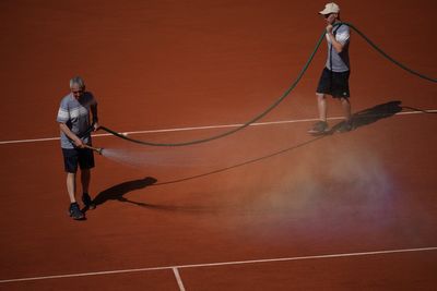 French Open groundskeepers drench the clay courts with water and salt during heat wave