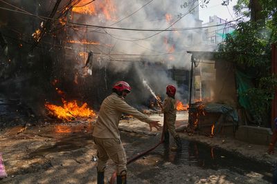 Women and children who jumped from windows among 21 dead in major fire at Delhi hotel