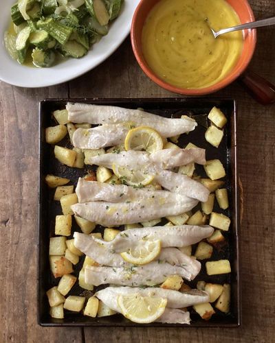 Rachel Roddy’s recipe for baked fish and potatoes with oregano and lemon mayonnaise