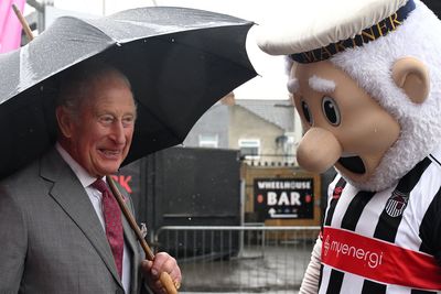 Charles braves downpour to meet football club’s mascot