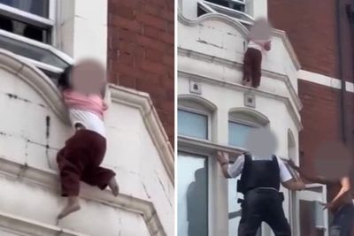 Child dangling from rooftop window above London shop rescued by police and bystanders