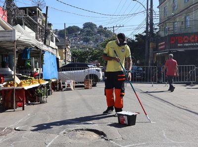Brazilians paint streets to celebrate World Cup after deadly police raid: ‘Why not transform this place?’