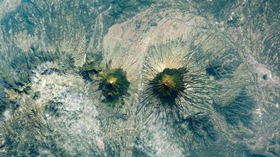 Indonesia's near-identical, 'Twin Peaks' volcanoes form striking mirror image — Earth from space