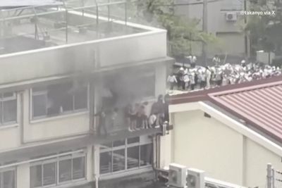 Children wait for rescue on window ledge as fire rages at Tokyo school