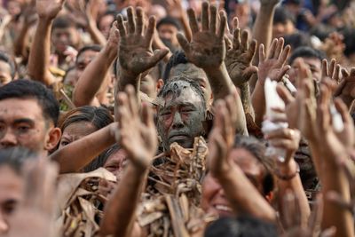 Photos show Philippine Catholics smearing mud on their bodies for festival honoring John the Baptist