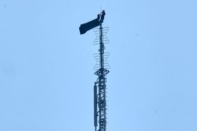 2 people hang banner about 'the power of love' on Empire State Building antenna
