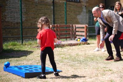 William plays bowls with schoolchildren as Harry makes first visit of UK trip