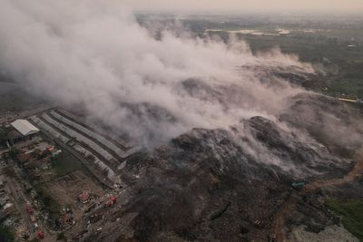 Trash ‘mountain’ fire burning for over a week near Indonesian capital doused as hundreds fall ill