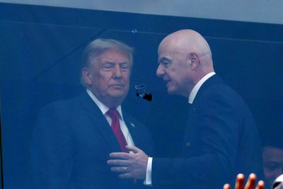 Trump pats FIFA trophy for good luck as he and Melania sit with Infantino behind protective glass at World Cup final