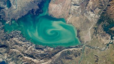 Giant, milky-green vortex swirls across massive 'cryptodepression' lake in Southern Europe — Earth from space
