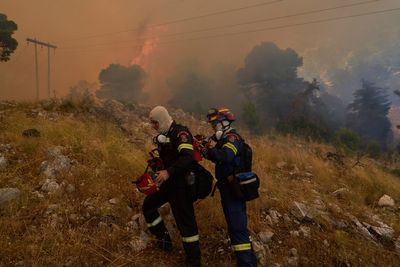 Firefighters scramble to contain fires outside Athens before winds and high temperatures return