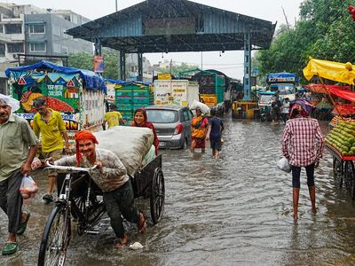 Delhi rain floods streets, disrupts traffic; locals use makeshift raft to ferry school children