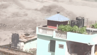 Watch: Family watches in horror from balcony as strong floodwaters wash away everything but their house