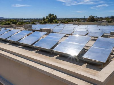 In 2020, Stanford's radiative cooling technology reached a California supermarket roof; panels were estimated to save 15% to 20% energy, while a Tempe bus shelter film was reported 30°F cooler