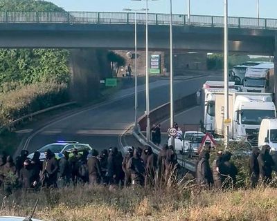 Black-clad protesters in balaclavas block road at port of Dover in Kent