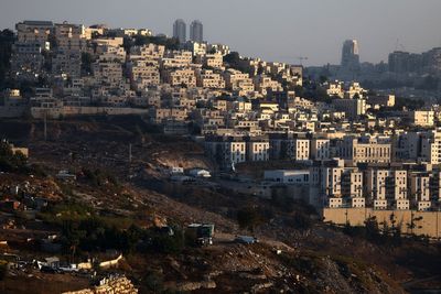 What are the Israeli settlements in the occupied West Bank and how has the UK sanctioned them?