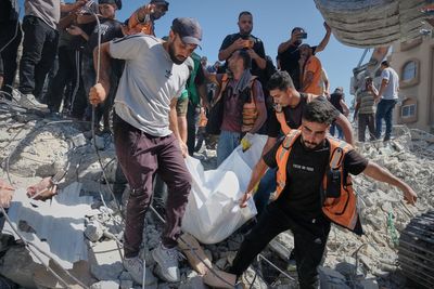 Photos show rescuers recovering bodies after strike-damaged building collapses in Gaza