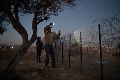 A flashlight and unseen settlers: Photographer conveys West Bank family's nightly watch in 1 photo