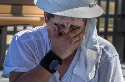 ‘Your body fights to stay cool’: workers toil in record heat as federal rule frozen