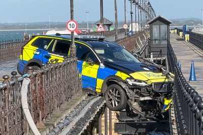 Police car left dangling mid-air after crashing through railings on UK pier