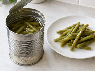 White sediment at the bottom of canned green beans can resemble spoilage, but hard-water minerals may react with natural bean compounds to form a harmless deposit