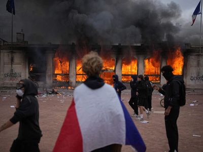 France’s protests rage as buildings burn, shops are looted and young protester loses hand; Vance blames immigration