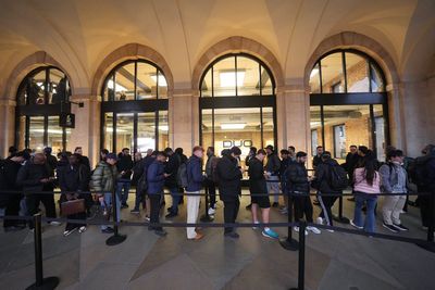 Apple fans brave Storm Austen to queue for release of iPhone Duo in London