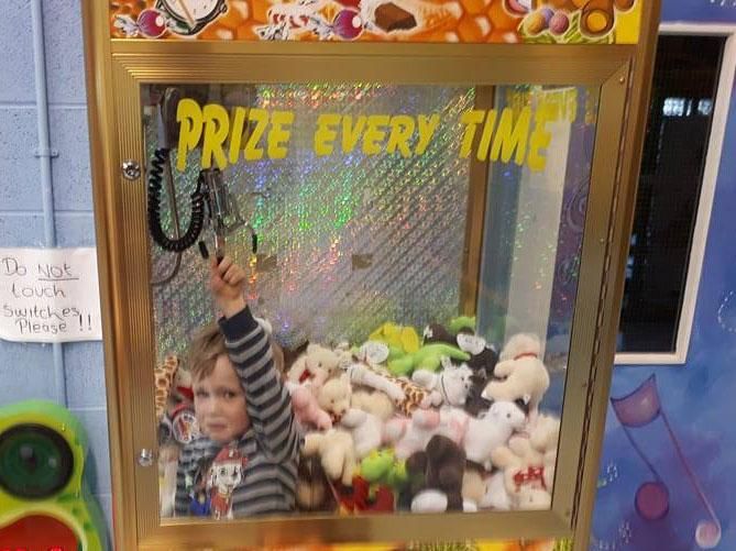 Frustrated child gets stuck inside toy claw machine