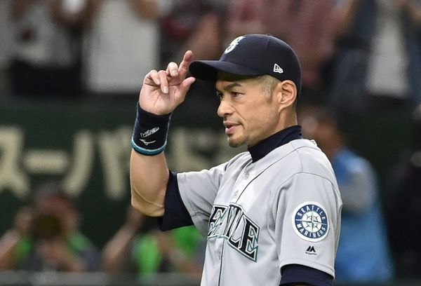 Seattle Mariners' Yusei Kikuchi (L) and Ichiro Suzuki talk during