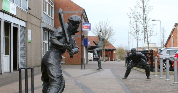 Why there are statues of 3 famous cricketers outside this town's library